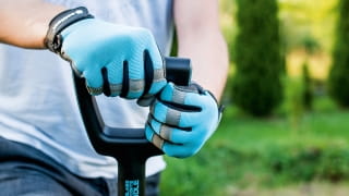 Niebieskie rękawice robocze z czarnymi wzmocnieniami na dłoniach